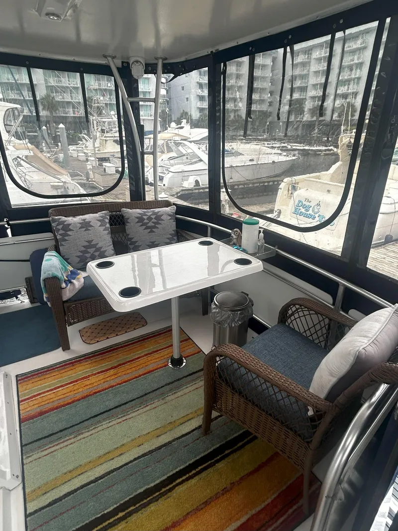 Slide: The Image of 1997 Mainship 34' M/Y yacht interior with seating, table, and marina view. - 5