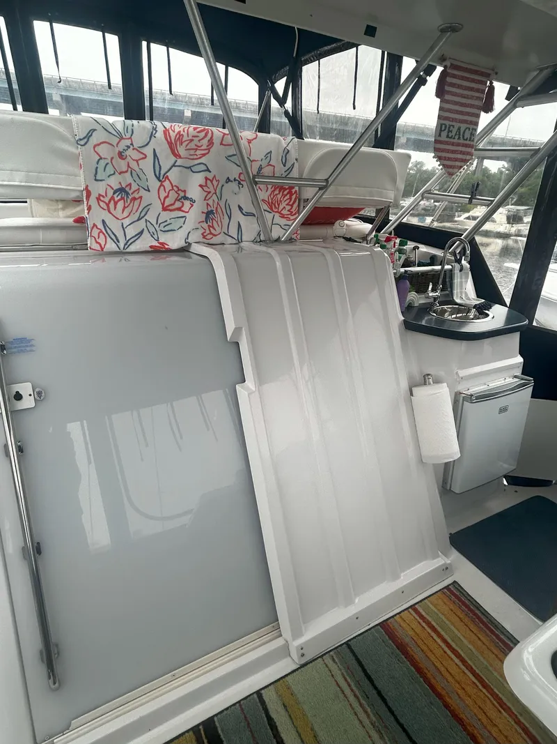 Slide: The Image of 1997 Mainship 34' M/Y boat interior with floral decor and kitchenette. - 6