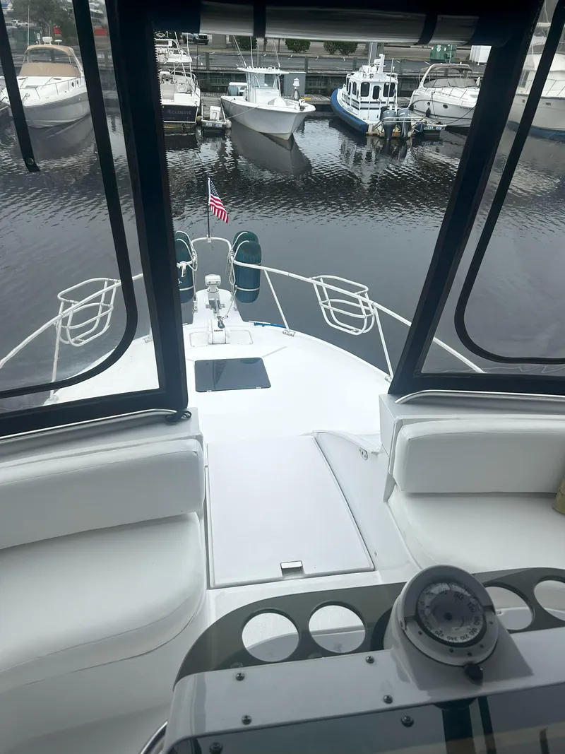 Slide: The Image of 1997 Mainship 34' M/Y yacht interior view, docked at marina with surrounding boats. - 9