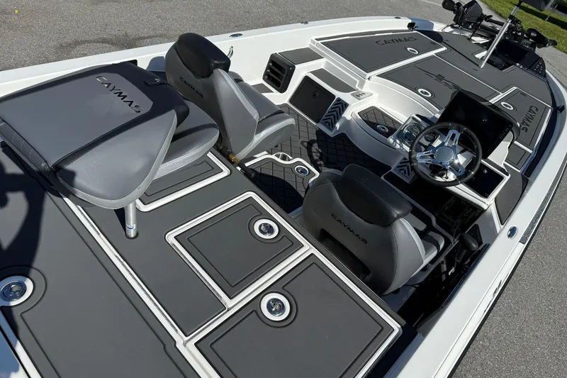 Slide: The Image of 2025 Caymas XS 21 boat interior with sleek seating and modern dashboard design. - 16