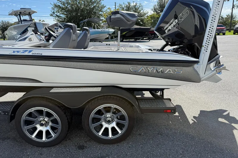 Slide: The Image of 2025 Caymas XS 21 boat on trailer, featuring sleek design and dual wheels. - 18
