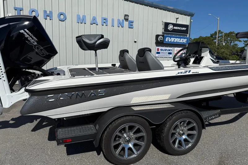 Slide: The Image of 2025 Caymas XS 21 boat at Toho Marine dealership, featuring sleek design and powerful engine. - 21