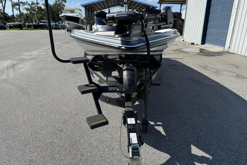 Slide: The Image of 2025 Caymas XS 21 boat on trailer, parked outdoors near storage facility. - 3