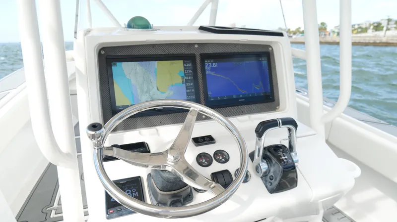 Slide: The Image of Center console of a 2004 Jupiter 31 FS boat with navigation screens and steering wheel. - 12