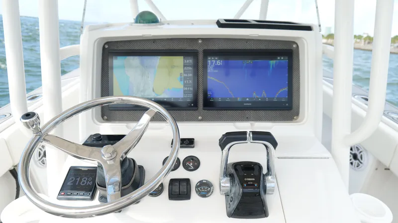 Slide: The Image of Helm of 2004 Jupiter 31 FS boat with dual navigation screens and steering wheel. - 13