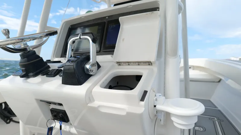 Slide: The Image of Control panel of a 2004 Jupiter 31 FS boat with open compartments and navigational equipment. - 16