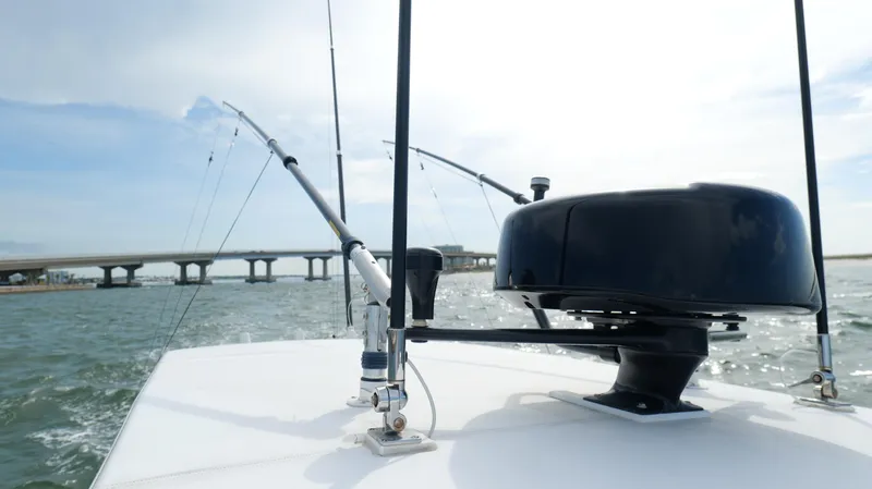 Slide: The Image of 2004 Jupiter 31 FS boat with fishing rods and radar, cruising near a bridge. - 20
