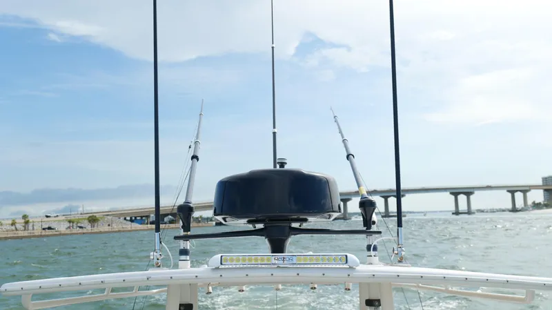 Slide: The Image of 2004 Jupiter 31 FS boat with fishing rods and radar, cruising near a bridge on a sunny day. - 21