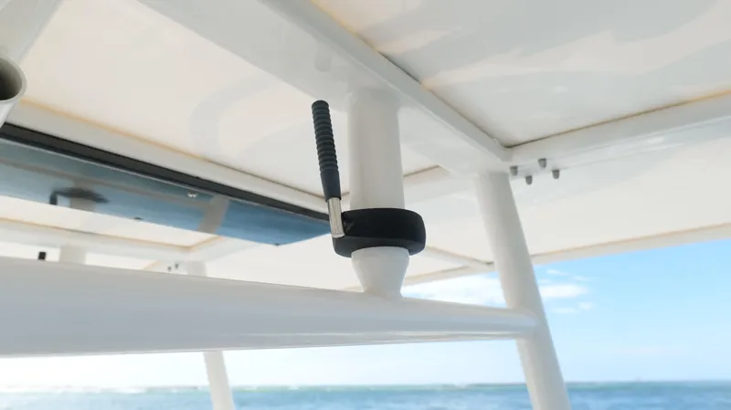 Slide: The Image of Close-up of a 2004 Jupiter 31 FS boat's T-top structure against a clear sky and ocean backdrop. - 23