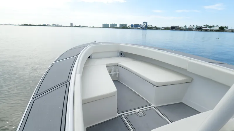 Slide: The Image of Bow seating area of a 2004 Jupiter 31 FS boat on calm water. - 24