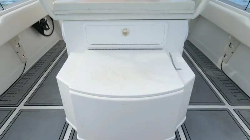 Slide: The Image of 2004 Jupiter 31 FS boat interior with white seating and storage compartment. - 36