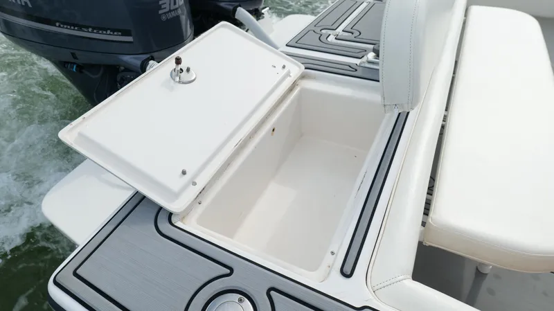Slide: The Image of Open storage compartment on a 2004 Jupiter 31 FS boat, with visible water in the background. - 43