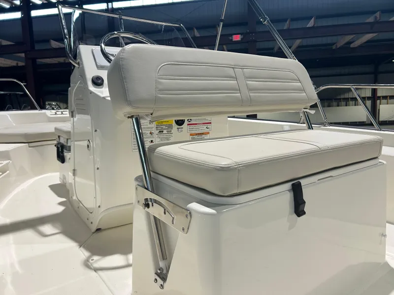 Slide: The Image of 2026 Boston Whaler 170 Montauk boat interior with cushioned seating and control console. - 16