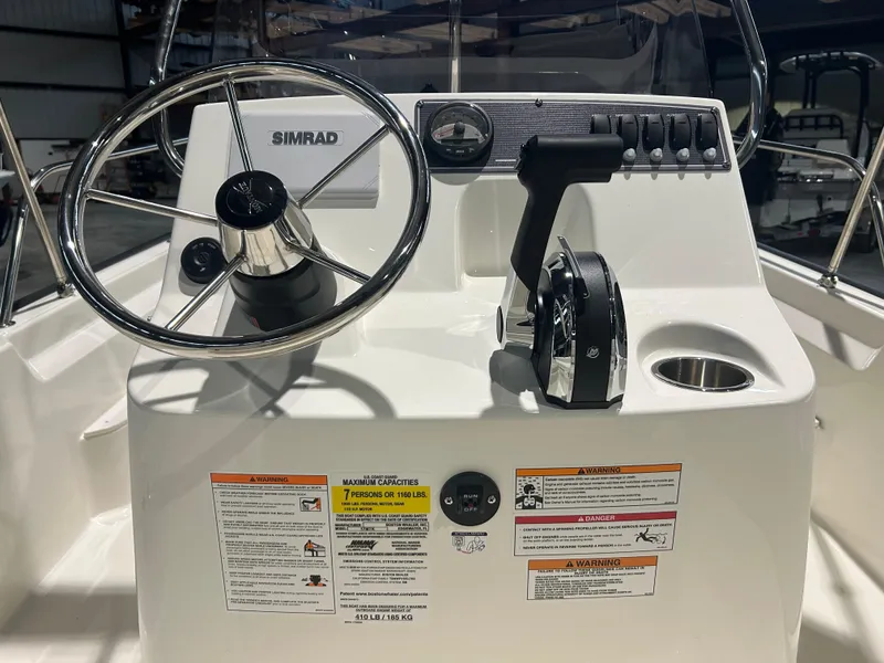 Slide: The Image of 2026 Boston Whaler 170 Montauk boat console with steering wheel and controls. - 19