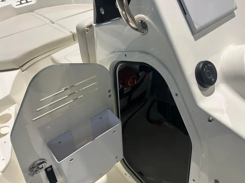 Slide: The Image of 2026 Boston Whaler 170 Montauk boat interior with open storage compartment and ignition switch. - 21