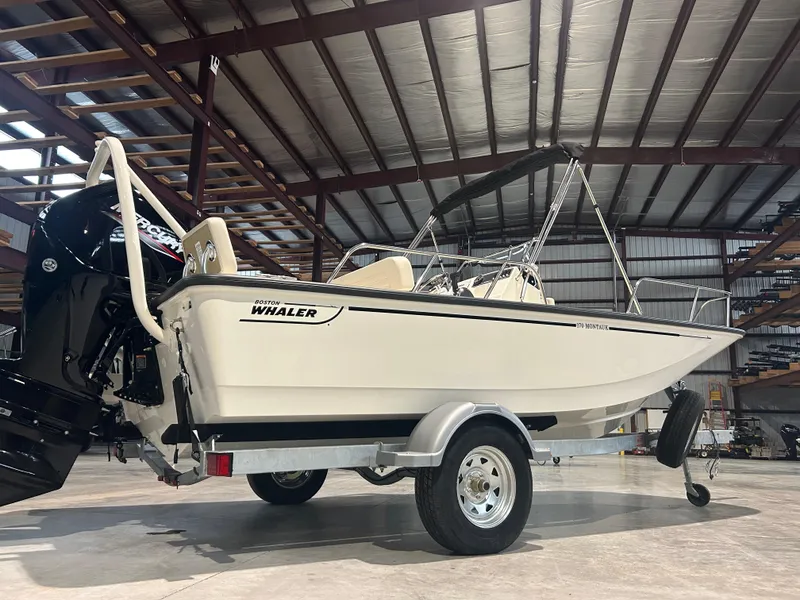 Slide: The Image of 2026 Boston Whaler 170 Montauk boat in a warehouse, on a trailer. - 3