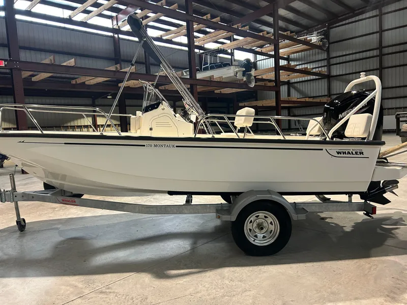 Slide: The Image of 2026 Boston Whaler 170 Montauk boat on trailer in warehouse setting. - 5