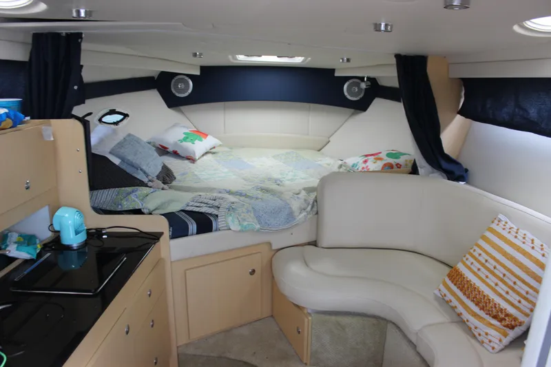 Slide: The Image of Interior of 2012 Bayliner 315 Cruiser with cozy bed, kitchenette, and seating area. - 16