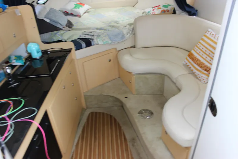 Slide: The Image of Interior of 2012 Bayliner 315 Cruiser with cozy seating and compact kitchen area. - 17