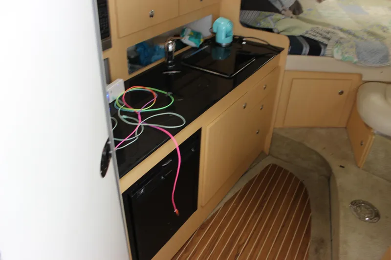 Slide: The Image of Interior of 2012 Bayliner 315 Cruiser with kitchenette and cozy sleeping area. - 19