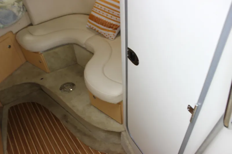 Slide: The Image of 2012 Bayliner 315 Cruiser interior with curved seating and wooden flooring. - 20