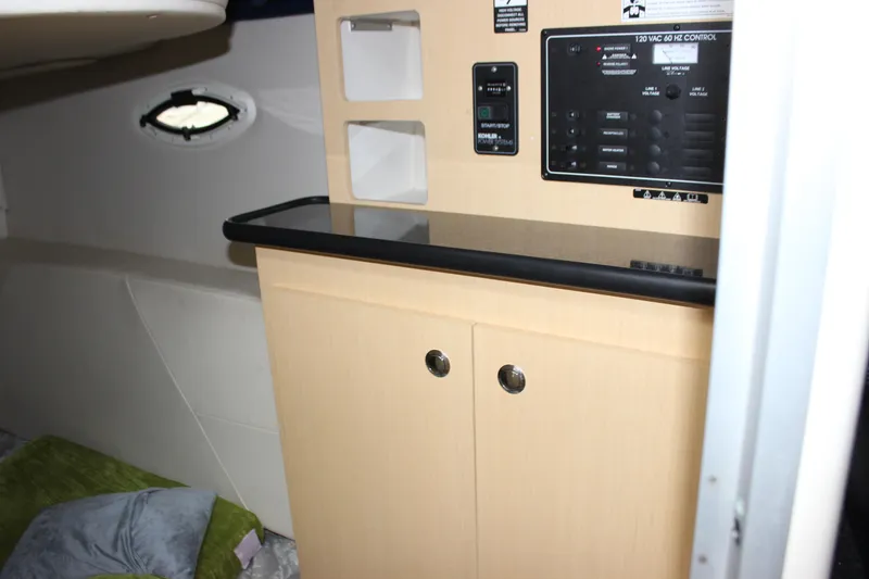 Slide: The Image of Interior of 2012 Bayliner 315 Cruiser with control panel and storage cabinets. - 27