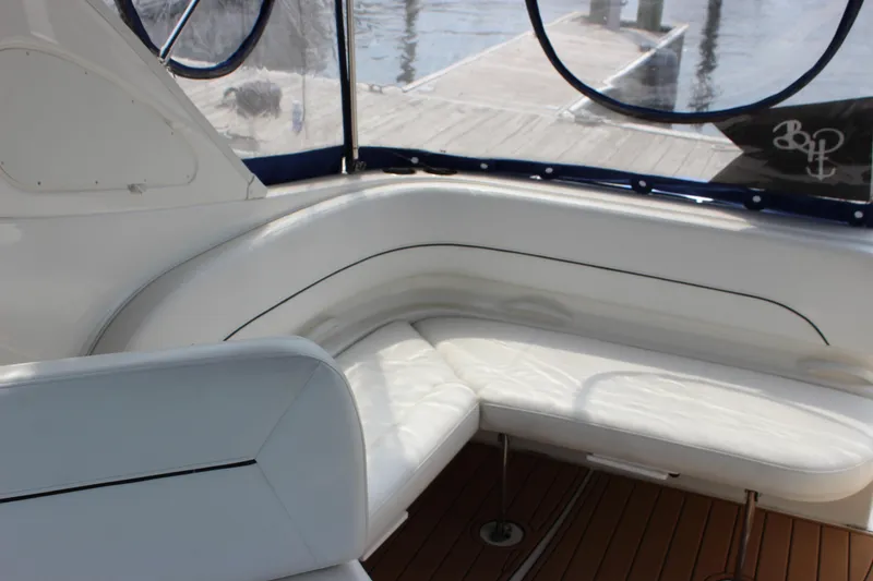 Slide: The Image of Interior of 2012 Bayliner 315 Cruiser with white seating and wood flooring. - 5
