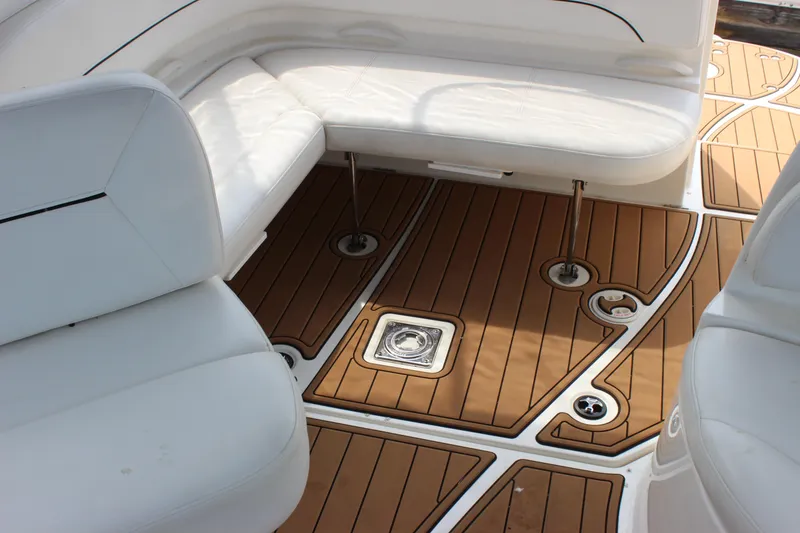 Slide: The Image of 2012 Bayliner 315 Cruiser interior with white seating and teak-style flooring. - 6