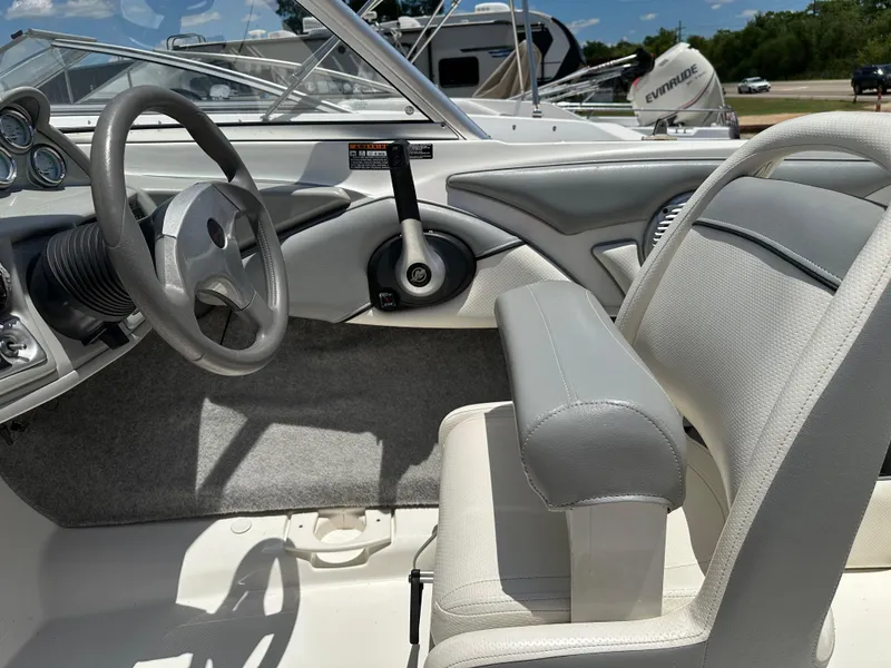 Slide: The Image of Interior of a 2011 Bayliner 184 SF boat, featuring steering wheel and seating. - 13