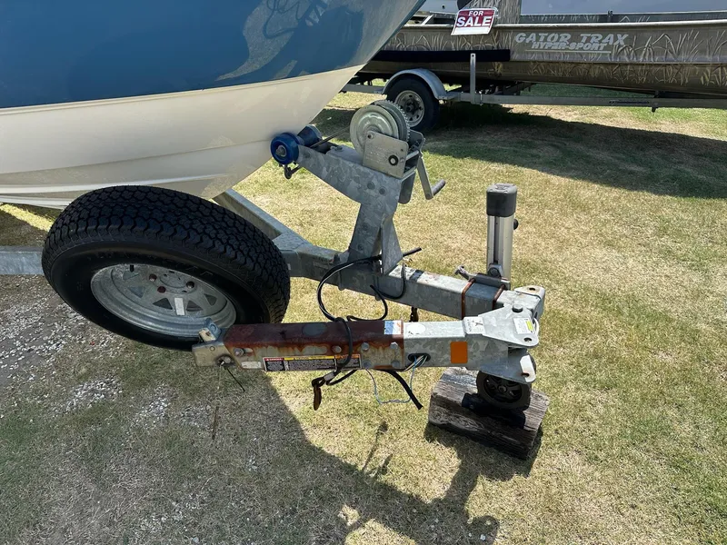 Slide: The Image of Trailer hitch of a 2011 Bayliner 184 SF boat on grass, with a "For Sale" sign. - 18