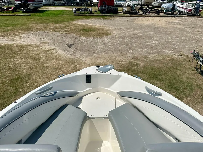 Slide: The Image of 2011 Bayliner 184 SF boat interior with gray seating, parked on grassy area. - 9