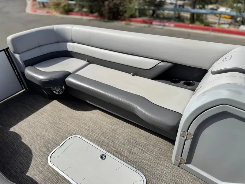 Slide: The Image of 2023 Godfrey Monaco 255 C pontoon boat interior with gray seating and storage compartment. - 11