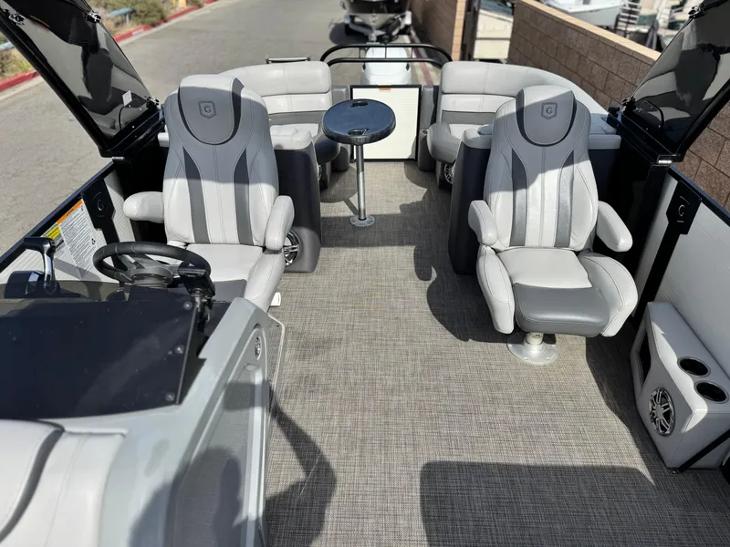 Slide: The Image of 2023 Godfrey Monaco 255 C pontoon boat interior with plush seating and table. - 14