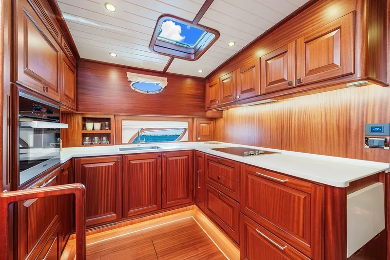 Slide: The Image of Luxurious 2024 Vicem 62 Classic yacht kitchen with rich wood cabinetry and modern appliances. - 18