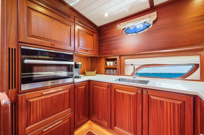 Slide: The Image of Luxurious 2024 Vicem 62 Classic yacht kitchen with wood cabinetry and modern appliances. - 19