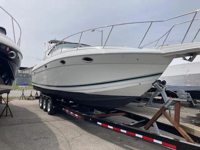 Slide: The Image of 1998 Formula 31 PC boat on trailer, white hull, docked outdoors. - 3