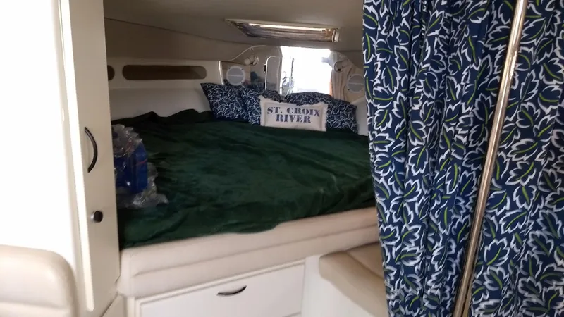 Slide: The Image of 1996 Doral 350SC cabin interior with bed, green bedding, and decorative pillows. - 16