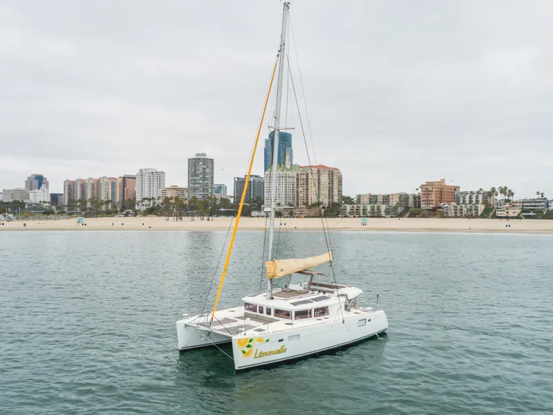 Slide: The Image of 2016 Lagoon 450F catamaran sailing near a city skyline and beach. - 15