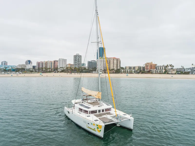 Slide: The Image of 2016 Lagoon 450F catamaran sailing near a city shoreline with tall buildings. - 17