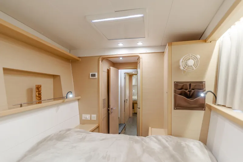 Slide: The Image of Interior of 2016 Lagoon 450F yacht cabin, featuring modern design and cozy bedding. - 27