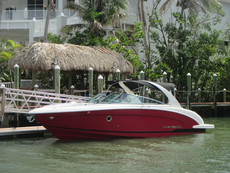 Slide: The Image of 2017 Regal 3200 Bowrider boat docked by a tropical waterfront. - 1