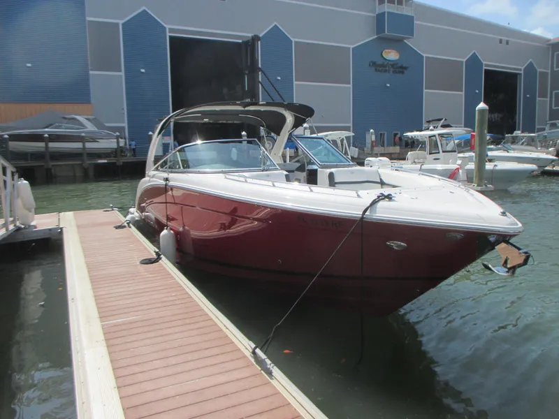 Slide: The Image of 2017 Regal 3200 Bowrider docked at marina, featuring sleek red design. - 3
