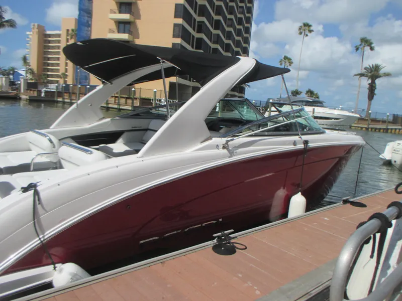 Slide: The Image of 2017 Regal 3200 Bowrider boat docked, featuring sleek design and maroon hull. - 6