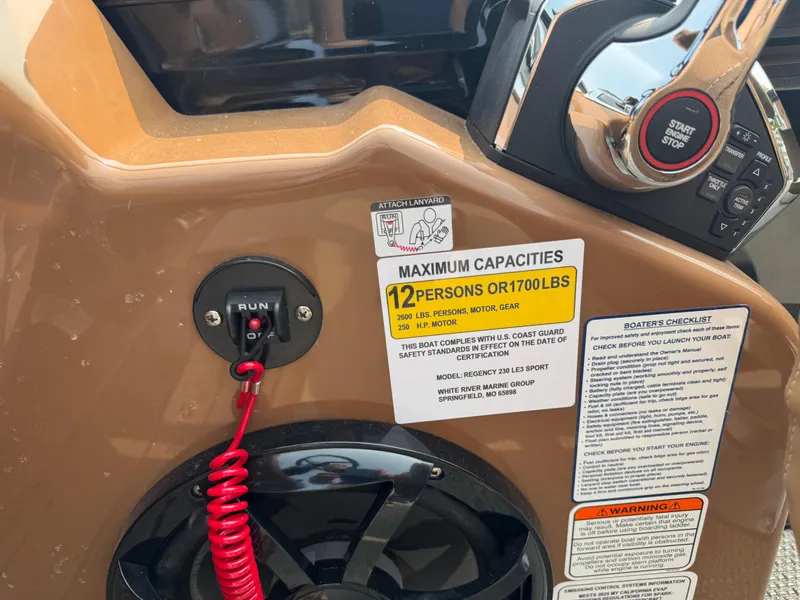 Slide: The Image of 2025 Regency 230 LE3 Sport boat dashboard with steering wheel and control panel. - 10