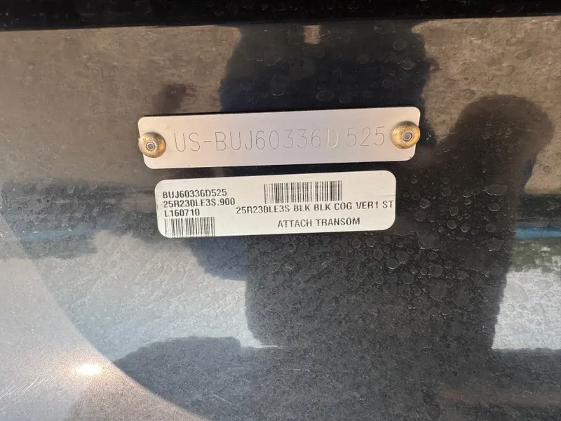 Slide: The Image of 2025 Regency 230 LE3 Sport with Mercury outboard motor in a storage area. - 5