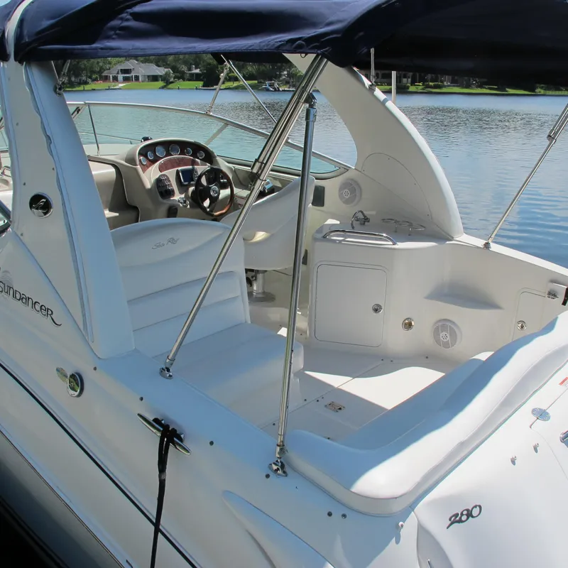 Slide: The Image of 2007 Sea Ray 280 DA boat interior with steering wheel and seating, docked by a lake. - 11