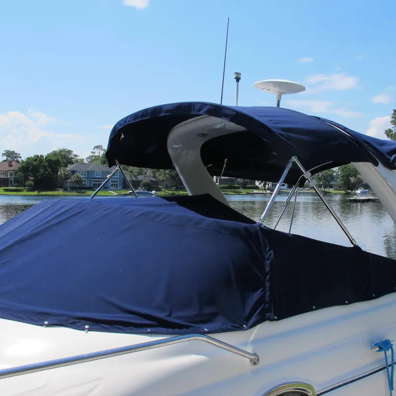 Slide: The Image of 2007 Sea Ray 280 DA boat with blue canvas cover on a sunny day by the water. - 2