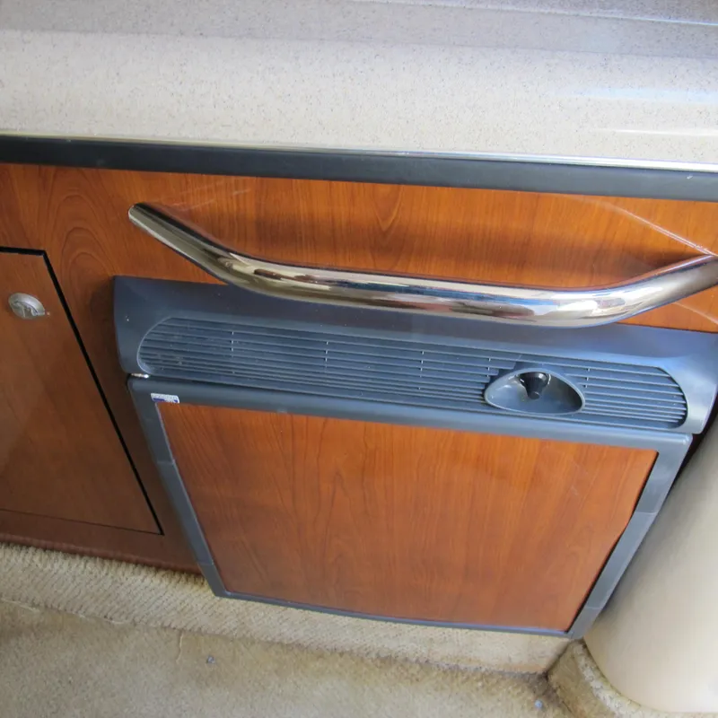 Slide: The Image of 2007 Sea Ray 280 DA cabin interior with wood paneling and compact fridge. - 24