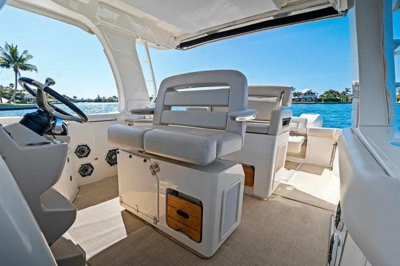 Slide: The Image of 2019 Boston Whaler 350 Realm interior with helm seats and ocean view. - 19