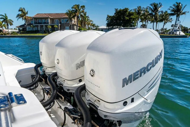 Slide: The Image of 2019 Boston Whaler 350 Realm with triple Mercury outboard engines on a sunny waterfront. - 29